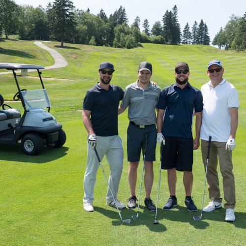 quatre joueurs de golf devant un cart